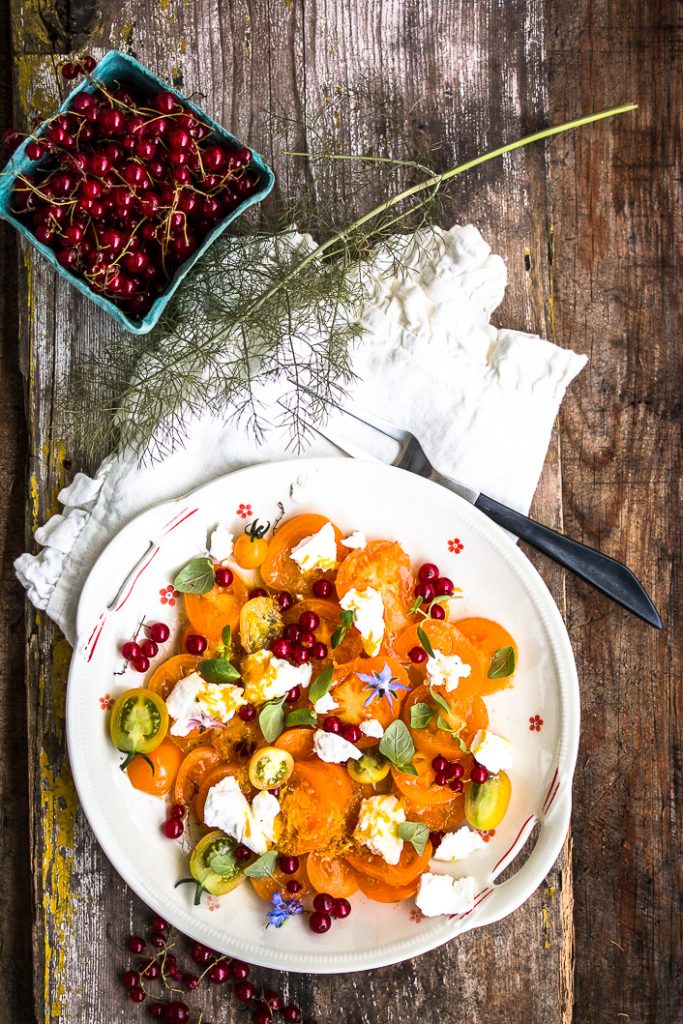 Salat mit gelben Tomaten, roten Johannisbeeren, Ziegenfrischkäse und ...