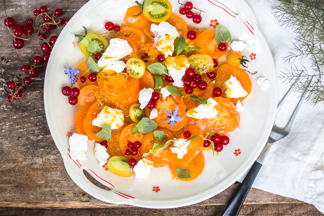 Salat mit gelben Tomaten, roten Johannisbeeren, Ziegenfrischkäse und ...