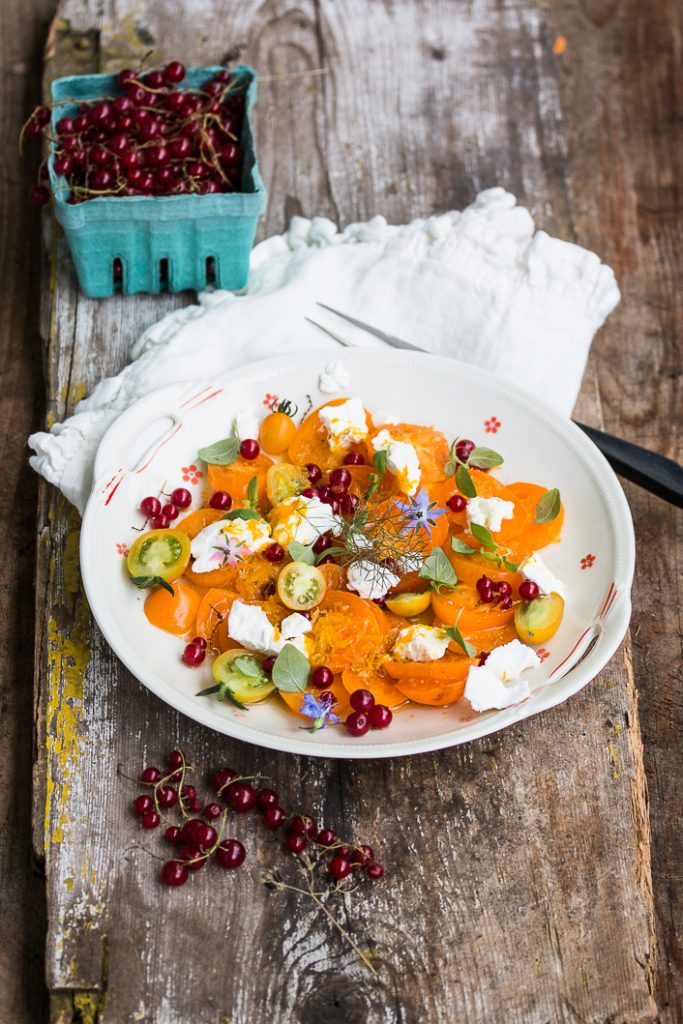 Salat mit gelben Tomaten, roten Johannisbeeren, Ziegenfrischkäse und ...